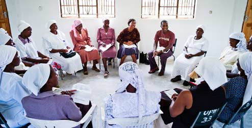 A Progressio development worker talks with a group of women about the living with HIV